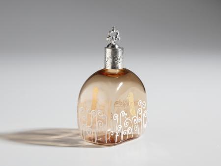 Bottiglia da profumo di gusto Secessionista, Murano, Vetro trasparente rosambrato con decori a smalti bianchi e oro e superficie leggermente iridata; collo e tappo in argento, 13.0 x 7.5 x 5.5 cm